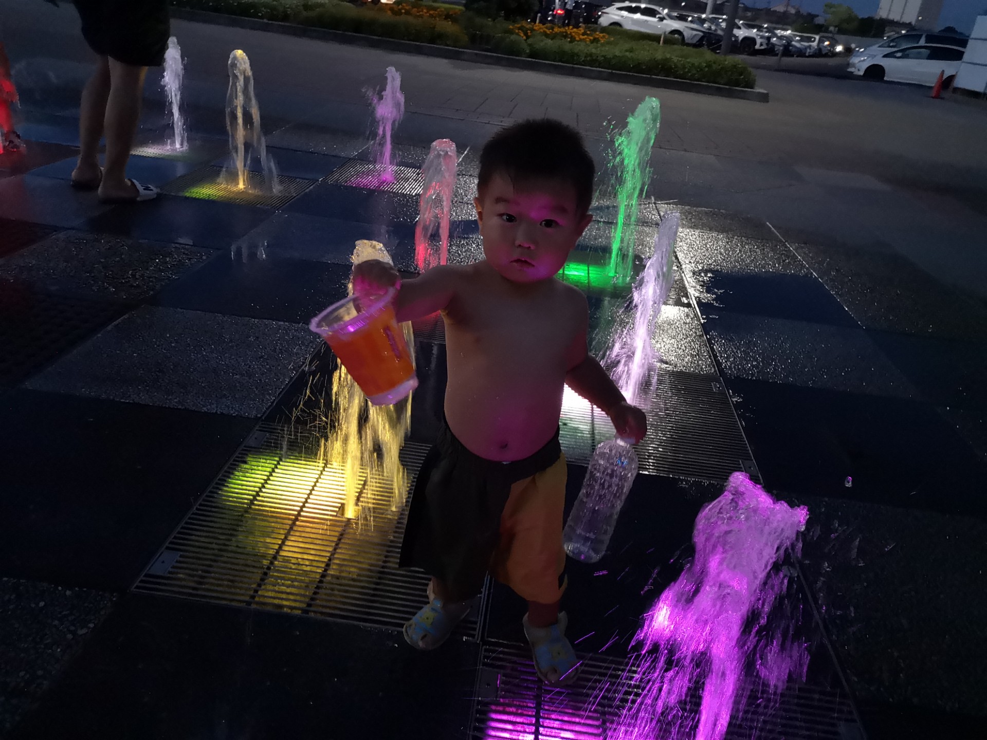 夜ライトアップされる噴水の場所で遊ぶ長男の写真